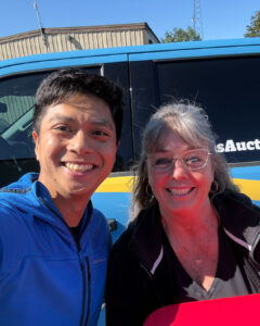 Bryan's Senior Marketing Coordinator Herald Silvestre with 2026 Bryan's Yeti Giveaway winner Christine Lenselink in front of a blue Byran's truck